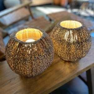 Luminária de mesa artesanal feita de fibra de açaí trançada, criando um efeito aconchegante de luz e sombra para mesas de cabeceira, criados-mudos ou salas.