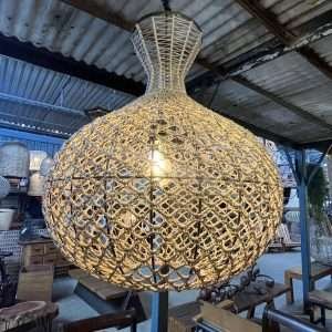 Luminária pendente artesanal feita de fibra natural trançada, criando um efeito de luz e sombra aconchegante para ambientes internos.