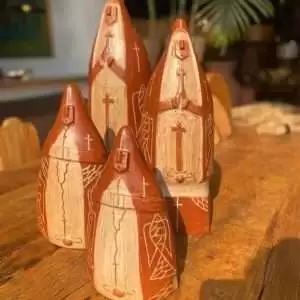 Escultura de Nossa Senhora feita em barro artesanal, com detalhes em textura rústica e acabamento natural, representando a santa com manto e vestes tradicionais.