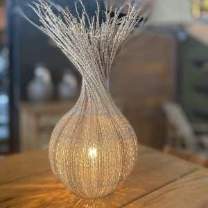 Luminária de mesa Moringa feita de fibra de açaí trançada, com base redonda e padrão de trança artesanal, criando uma iluminação suave e aconchegante.