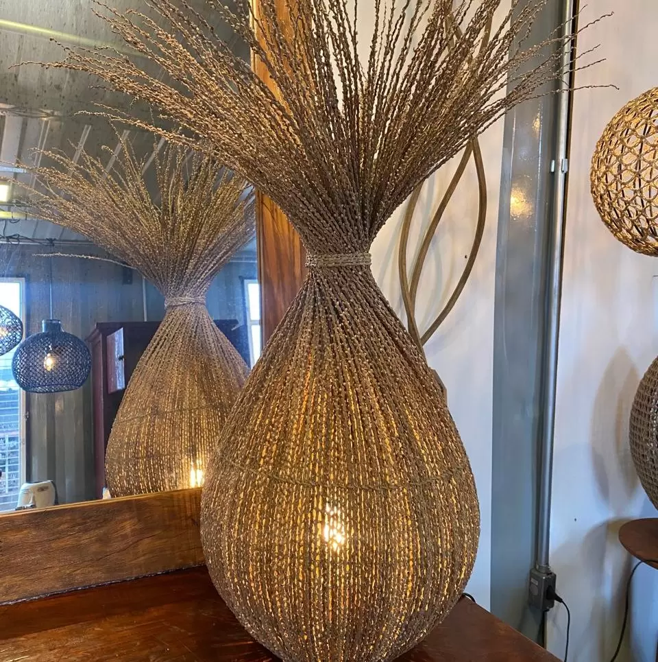 Luminária de fibra natural suspensa com design orgânico, perfeita para iluminação ambiente e aconchegante.