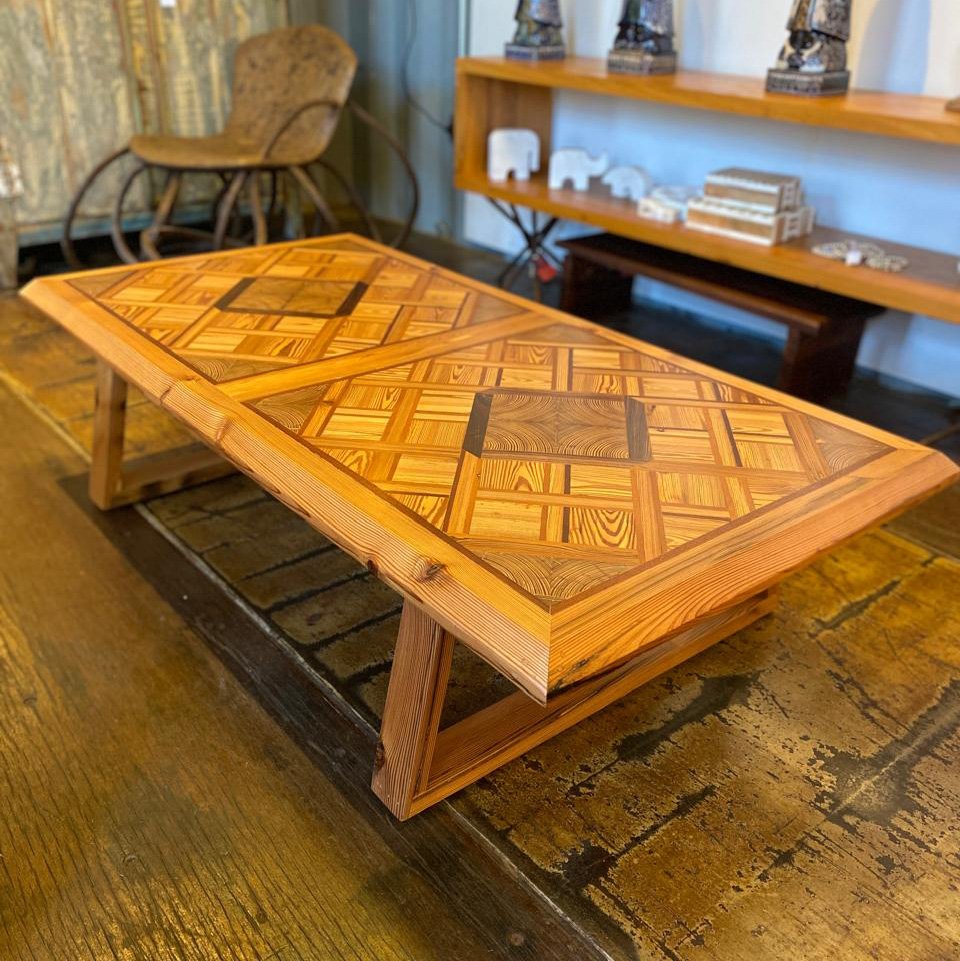 Mesa de centro em madeira maciça com marchetaria artesanal geométrica e acabamento sofisticado para decoração de ambientes elegantes.